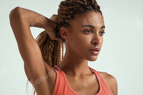 Preview: Perfect body. Close up of beautiful young african woman in sportswear holding her hair in hand and