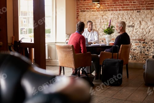 Preview: A middle aged gay male couple check in at a boutique hotel