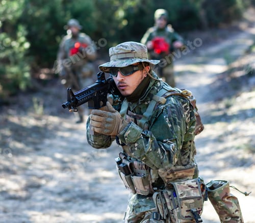 Preview: Man in Camouflage with Gun in Woodland Setting