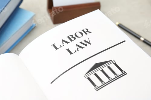 Preview: Open book with words LABOR LAW on table, closeup