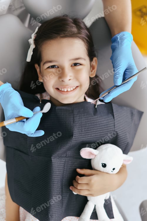 Preview: Little beautiful girl at the dentist looking at the camera and smiling