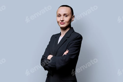 Preview: Portrait of serious business 30s woman with crossed arms on grey background