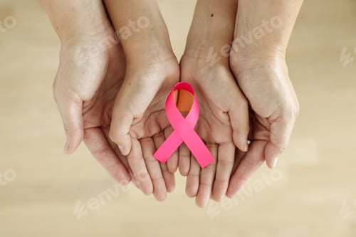 Preview: Mother and daughter's hands holding a pink ribbon, top view, Breast cancer awareness