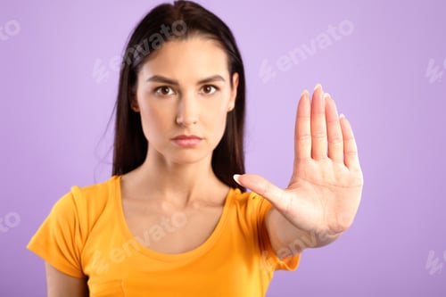 Preview: Serious girl showing stop sign with hand