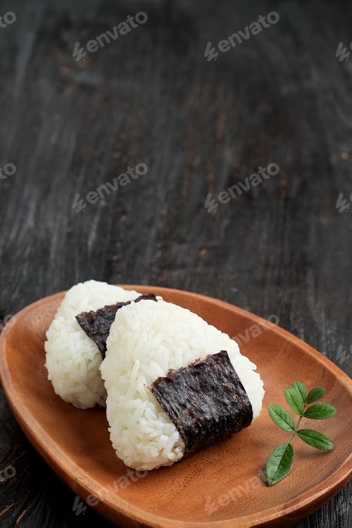 Preview: Onigiri, Japanese Rice Triangle with Nori Seaweed on Wooden Plate.