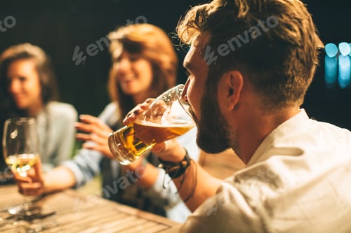 Preview: Group of friends drink beer on the terrace during summer night