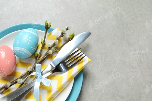 Preview: Festive Easter table setting with painted eggs on color background, top view. Space for text