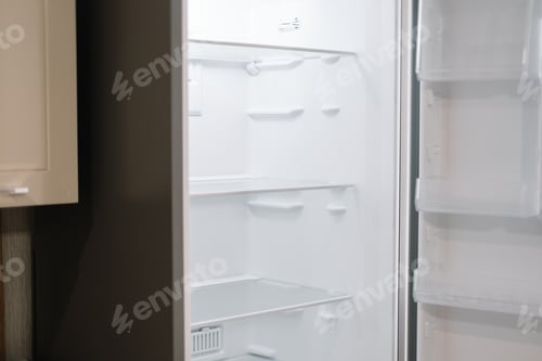 Preview: Empty open white refrigerator in the kitchen.