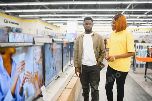 Preview: Beautiful couple buying consumer tech products in modern home appliances store.