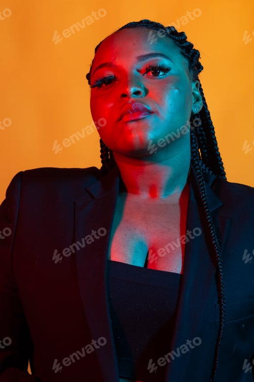 Preview: Close up beauty fashion portrait of an attractive young african woman wearing dreadlocks over orange