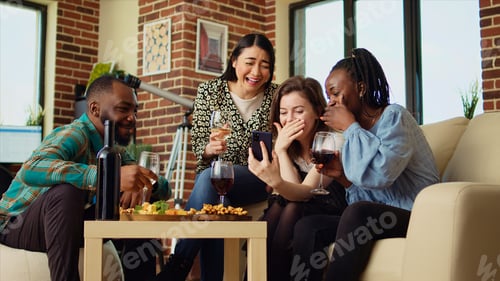 Preview: Friends at reunion looking at funny videos from their childhood on smartphone screen