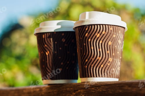 Preview: Two coffee cups balcony natural daylight blurred background. Beverages shop discount Hot drink to go