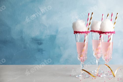 Preview: Cocktail with cotton candy in glasses on table. Space for text
