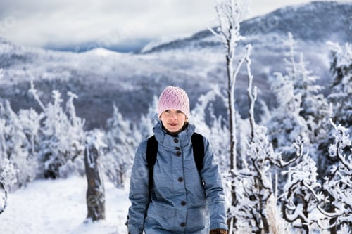 Preview: Woman Hiking in Beautiful Snow Covered Winter Wonderland