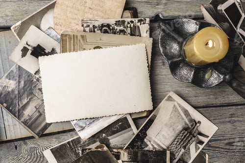 Preview: Collection of old black and white photos with a candle on a wooden table
