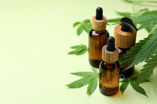 Preview: Bottles with cannabis oil and leaves on green background