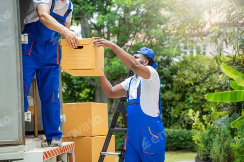 Preview: Two removal company workers are unloading boxes from a mini truck into new home.