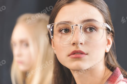 Preview: portrait of beautiful pensive caucasian teenage girl in eyeglasses looking away