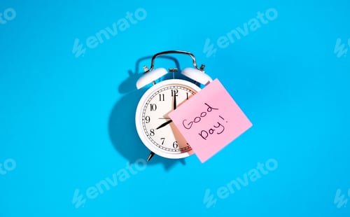 Preview: White alarm clock and a sticker with the inscription Good day on a blue background.