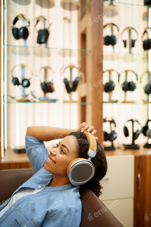 Preview: Happy woman listening to music, headphones store