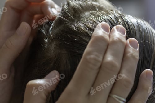 Preview: Closeup of a mother checking the hair of her daughter against lice