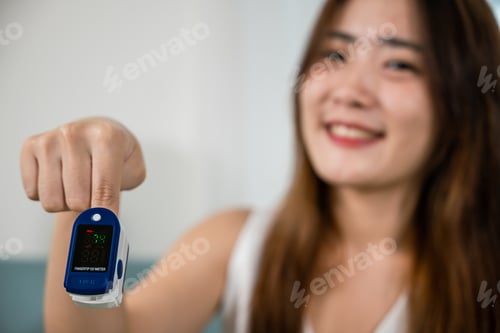 Preview: Young woman finger inserted into the pressure oximeter to assess health
