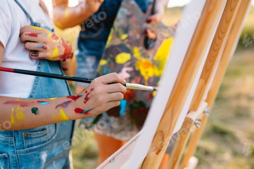 Preview: Beauty mother paint with her little daughter. Stylish woman drawing the picture with little girl