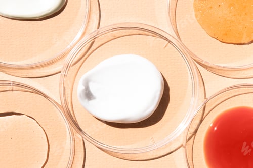 Preview: Smears of different cosmetic textures in glass containers close-up.