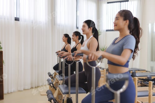Preview: Women exercising pilates on reformer chairs in studio