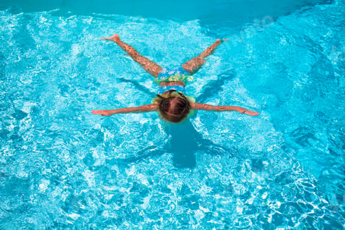 Preview: Little cute happy girl swimming in outdoor pool like a star