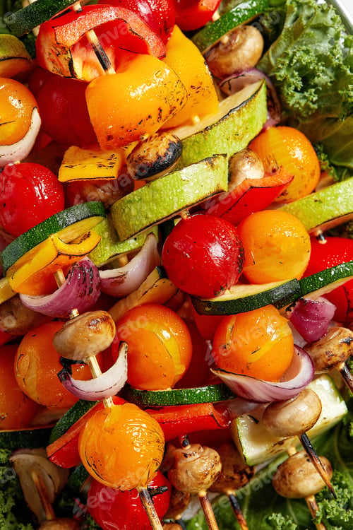 Preview: vegetarian skewers with dry herbs on wooden skewers of zucchini tomato onion mushrooms on a plate