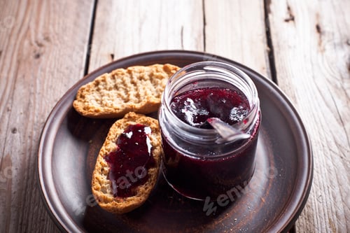 Preview: black currant jam in glass jar and crackers