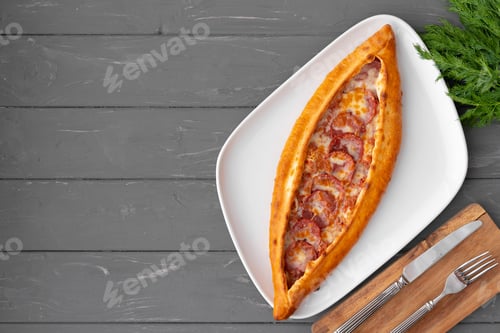 Preview: Turkish stuffed flatbread pide on gray wooden table