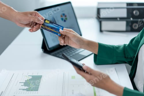 Preview: A woman is handing a credit card to another person