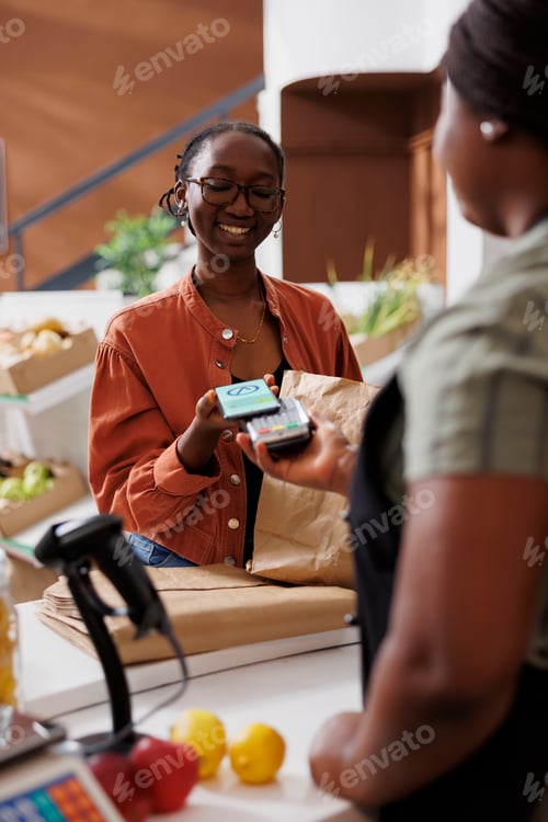 Preview: Smiling woman making nfc payment