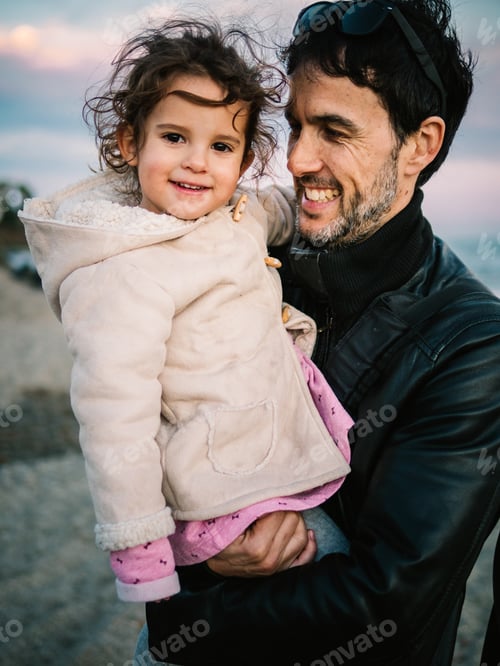 Preview: father holding little daughter at the beach