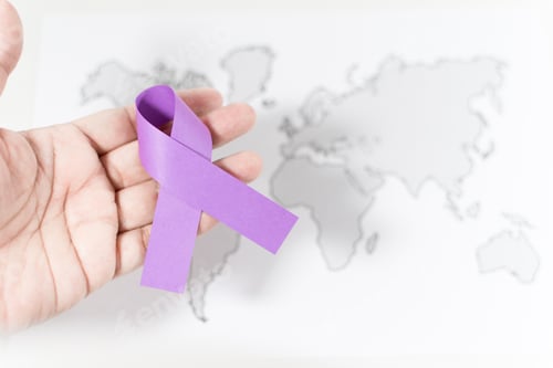 Preview: Purple ribbon on a person's hand - awareness of violence against women concept