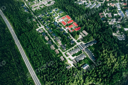 Preview: Aerial view of residential houses neighborhood in green woods with road in Finland