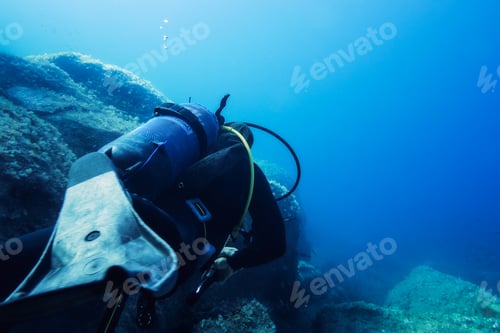 Preview: diver submerged in the blue sea near of the seabed
