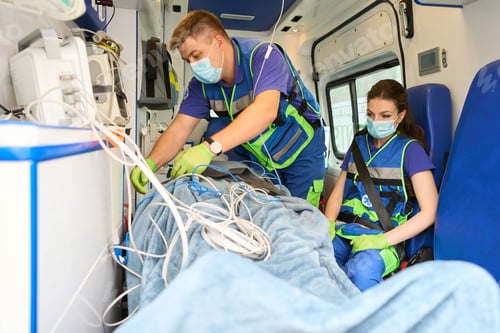 Preview: Doctor fastens patient in ambulance to stretcher with seat belt