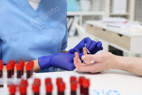 Preview: Laboratory testing. Doctor taking blood sample from patient at white table in hospital, closeup