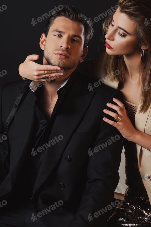 Preview: attractive woman hugging handsome man in suit isolated on black