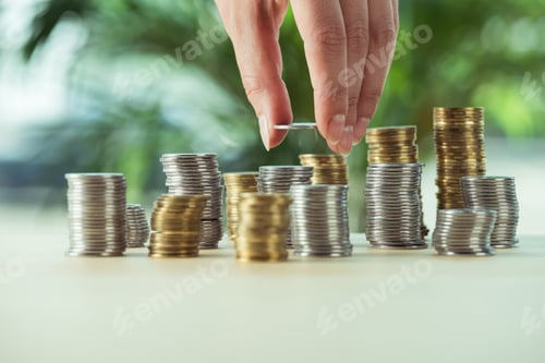 Preview: cropped view of person stacking coins on table, investment concept