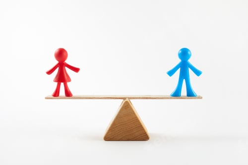 Preview: Gender equality concept. Male and female toy on the scales with balance