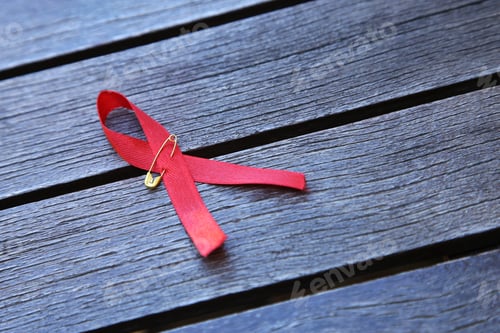 Preview: High angle shot of a Blood Cancer Awareness red ribbon on a wooden surface