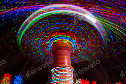 Preview: Carnival amusement park ride with swings. Spinning fair ride at night with bright lights