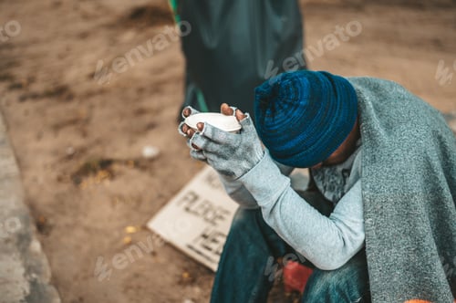 Preview: Man sitting beggar with a cup and money.
