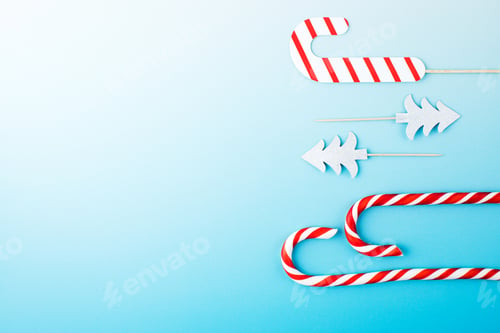 Preview: Christmas red and white lollipops on a gradient blue background. Christmas background.
