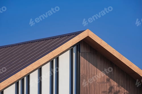 Preview: Side view of vintage wooden gable roof with battens decoration against blue sky background