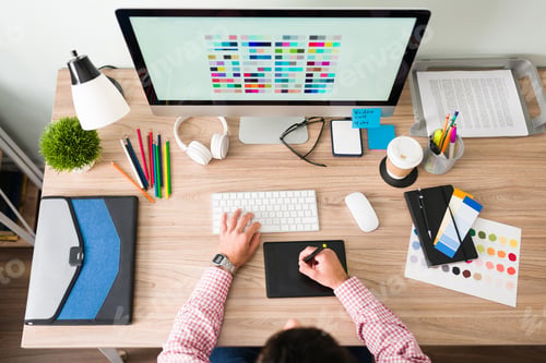 Preview: Top view of a graphic designer working at his office desk